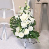 Bukiet na cmentarz Noce w Rodanthe nr 378 Bukiet na cmentarz Noce w Rodanthe nr 378 to przepiękna  i nowoczesna dekoracja nagrobna.  Przepiękne białe eustomy oraz róże w eleganckim odcieniu bieli wykorzystane w bukiecie na cmentarz, pięknie ze sobą współgrają, tworząc śliczną dekorację. Kwiaty wykorzystane do tej dekoracji nagrobnej są bardzo wysokiej jakości. Dekoracja niezależnie od pory roku będzie prezentować się pięknie.  Prosta forma nadaje kompozycji lekkości i elegancji.  Wysokiej jakości kwiaty oraz harmonia kompozycji pięknie będzie prezentować się zarówno na ciemnym jak i jasnym nagrobku. Zielone elementy podkreślają kolor kwiatów.  Dekoracja niespotykana i bardzo elegancka. Bukiet osadzony w plastikowym wkładzie. Na zamówienie możemy wykonać go również w formie bukietu bez wkładu, jak na zdjęciach. Jest to elegancka alternatywa dla tradycyjnych wiązanek, sprzedawanych pod cmentarzami. Jeżeli spodobał się Wam nasz Bukiet na cmentarz Noce w Rodanthe nr 378 możemy dla Was przygotować w komplecie inne elementy dekoracyjne, takie jak wianki, stroiki, bukiety itp., zgodnie z Waszymi życzeniami, które możecie nam przekazać. Wymiary bukietu na cmentarz: Wysokość razem z wkładem 67 cm Nie ma dwóch takich samych Każda z naszych dekoracji jest wykonywana ręcznie, więc gwarantujemy, że dekoracja dostarczona Wam będzie jedyna w swoim rodzaju. Ze względu na to, że nasze kompozycje wykonywane są za każdym razem ręcznie przez florystę oraz sezonowość wykorzystywanych w kompozycjach dodatków – kompozycja przygotowana dla Państwa może delikatnie różnić się od przedstawionej na zdjęciu. Gwarantujemy natomiast jakość i estetykę wykonania Państwa zamówienia. Kompozycja na cmentarz w jesiennych kolorach Kompozycja nagrobna nr. 133 Kompozycja na cmentarz z hortensją nr.126
