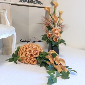 Zestaw nagrobny w Cieniu Kasztanowca nr 380 Zestaw nagrobny w Cieniu Kasztanowca nr 380 to unikatowa i piękna kompozycja kwiatowa. Zestaw składa się z kompozycji leżącej oraz bukietu.  Kompozycja jest przede wszystkim jest niezwykle elegancka i duża. Składają się na nią kolejno : róże i gumowe kalie .10 kalii w kolorze cappuccino o długości 72 cm  zostało ułożone warstwowo w kuli kwiatowej. Całość osadzona jest na betonowej podstawce, by zabezpieczyć kompozycję przed wiatrem. Kalie i róże pięknie ze sobą współgrają tworząc harmonijną całość. Bukiety stworzone do zestawu będą strzeliste , w kolorze naturalna biel, z pięknymi powyginanymi kaliami. Możliwość zamówienia w następującej kolorystyce: czerwony, biały, fioletowy, bordo, różowo-kremowy, szary, szaro-różowy, szaro-fioletowy, szaro-niebieski. Wiązanka będzie prezentować się elegancko na praktycznie każdym większym nagrobku. Wszystkie kwiaty wykorzystane w kompozycji to wysokiej jakości sztuczne kwiaty. Jeżeli spodobała się Wam nasza Kompozycja nagrobna Zestaw nagrobny w Cieniu Kasztanowca nr 380,  możemy również przygotować dla Państwa zestaw w tej kolorystyce, z innymi elementami dekoracyjnymi, na przykład z bukietem do wazonu, stroikiem czy wiankiem. Wystarczy napisać do nas wiadomośc prywatną, by ustalić szczegóły zamówienia Wymiary Zestawu nagrobnego w Cieniu Kasztanowca nr 380: Długość  85-90 cm Wysokość bukietów: ok. 75-80 cm Nie ma dwóch takich samych Każda z naszych dekoracji jest wykonywana ręcznie, więc gwarantujemy, że dekoracja dostarczona Wam będzie jedyna w swoim rodzaju. Ze względu na to, że nasze kompozycje wykonywane są za każdym razem ręcznie przez florystę oraz sezonowość wykorzystywanych w kompozycjach dodatków – kompozycja przygotowana dla Państwa może delikatnie różnić się od przedstawionej na zdjęciu. Gwarantujemy natomiast jakość i estetykę wykonania Państwa zamówienia.