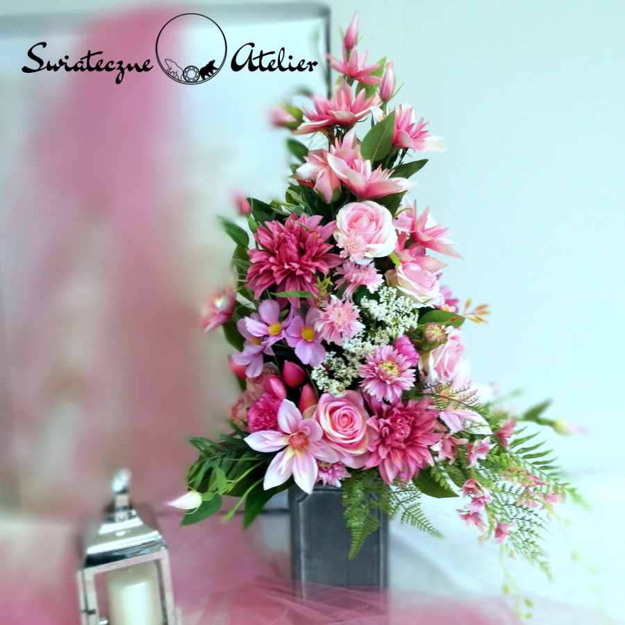 Bukiet nagrobny Róż i fuksja nr 761 Bukiet nagrobny Róż i fuksja nr 761 to wyjątkowa kompozycja kwiatowa.  Dekorację osadziliśmy w plastikowym, uniwersalnym wkładzie. Klimatyczne dodatki i zielone liście tworzą wyjątkową dekorację. Kwiaty, jakie występują w tej dekoracji nagrobnej są uniwersalnej urody i dekoracja niezależnie od pory roku będzie prezentować się pięknie.  Dobrej jakości materiały oraz harmonia kompozycji pięknie zaprezentują się zarówno na ciemnym jak i jasnym nagrobku. Zielone elementy kompozycji atrakcyjnie podkreślają kolor kwiatów. Śliczna kompozycja kwiatowa w różu tworzy niepowtarzalny klimat.